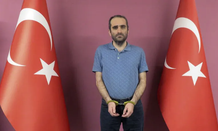 Selahattin Gulen, a nephew of U.S.-based Muslim cleric Fethullah Gulen, stands between Turkish flags in this photo provided by Turkish intelligence service in Ankara, Turkey, on May 31, 2021. (Turkish Intelligence Service via AP)