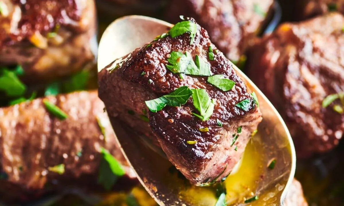 These tender morsels of steak are finished with fresh herb butter just before serving. (Joe Lingeman/TNS)