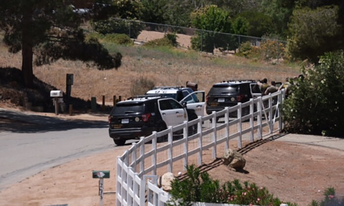 Police vehicles appear on the scene of a fire near a home in Acton, Calif., on June 1, 2021. (David Crane/The Orange County Register via AP)