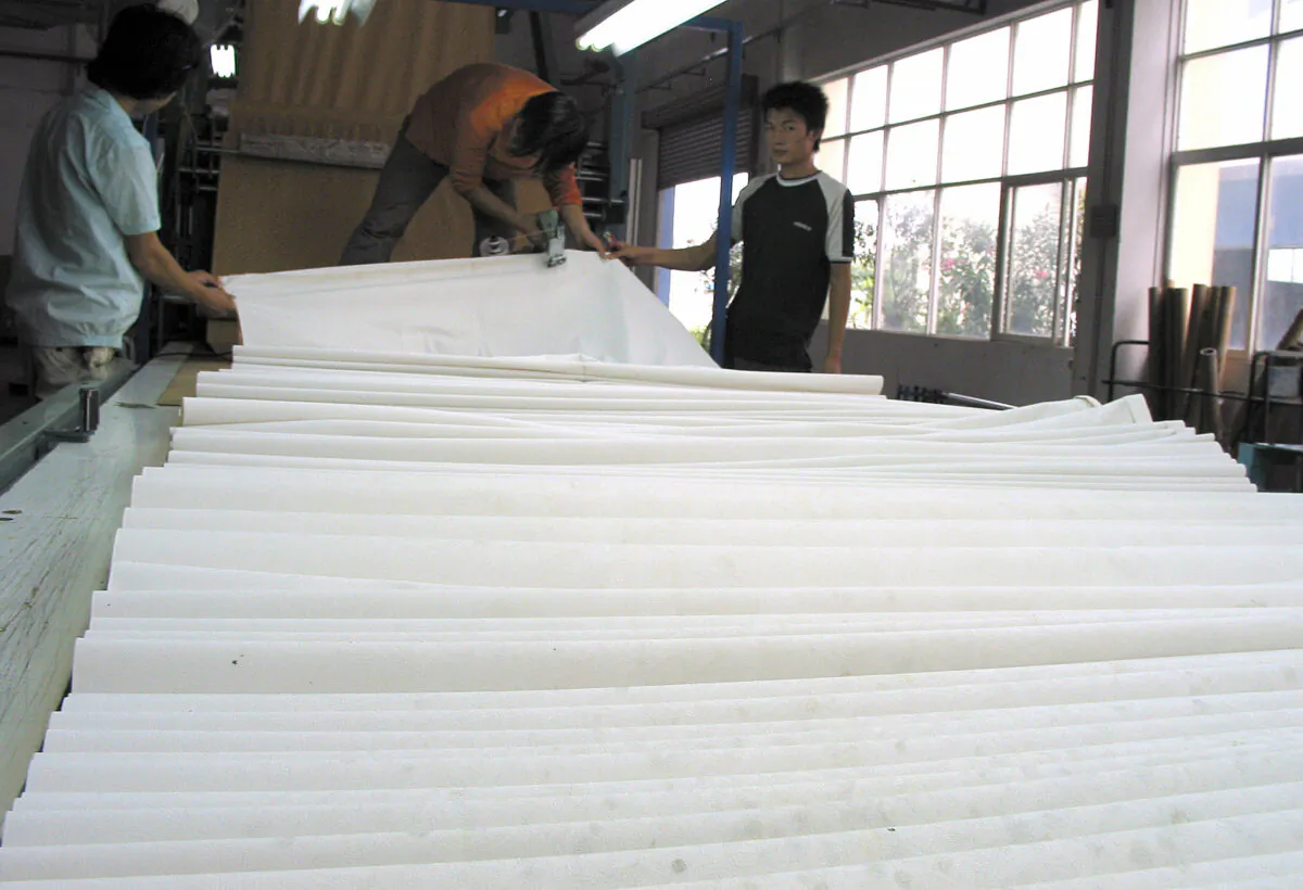 Workers oversee the production of paper at a paper mill in the southern Chinese city of Shenzhen on Oct. 19, 2006. (PETER HARMSEN/AFP via Getty Images)