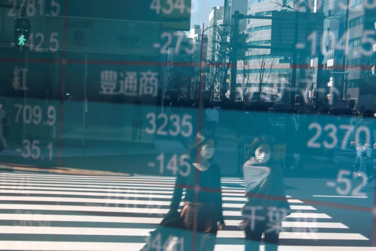 People are reflected on a screen showing Nikkei index, outside a brokerage in Tokyo, Japan, on Feb. 28, 2020. (Athit Perawongmetha/Reuters)