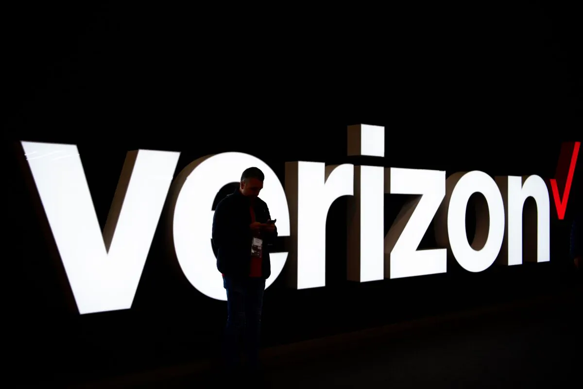 A man stands in front of the Verizon logo at the Mobile World Congress (MWC) in Barcelona on Feb. 25, 2019. (Gabriel Bouys/AFP via Getty Images)