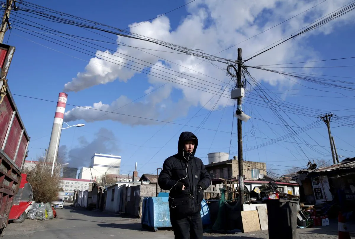 A man walks near a coal-fired power plant in Harbin, Heilongjiang Province, China, on Nov. 27, 2019. (Jason Lee/Reuters File Photo)