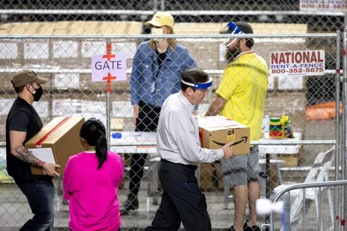 Former Arizona Secretary of State Ken Bennett (R) works with others to move ballots from the 2020 general election during an audit at Veterans Memorial Coliseum in Phoenix, Ariz., on May 1, 2021. (Courtney Pedroza/Getty Images)