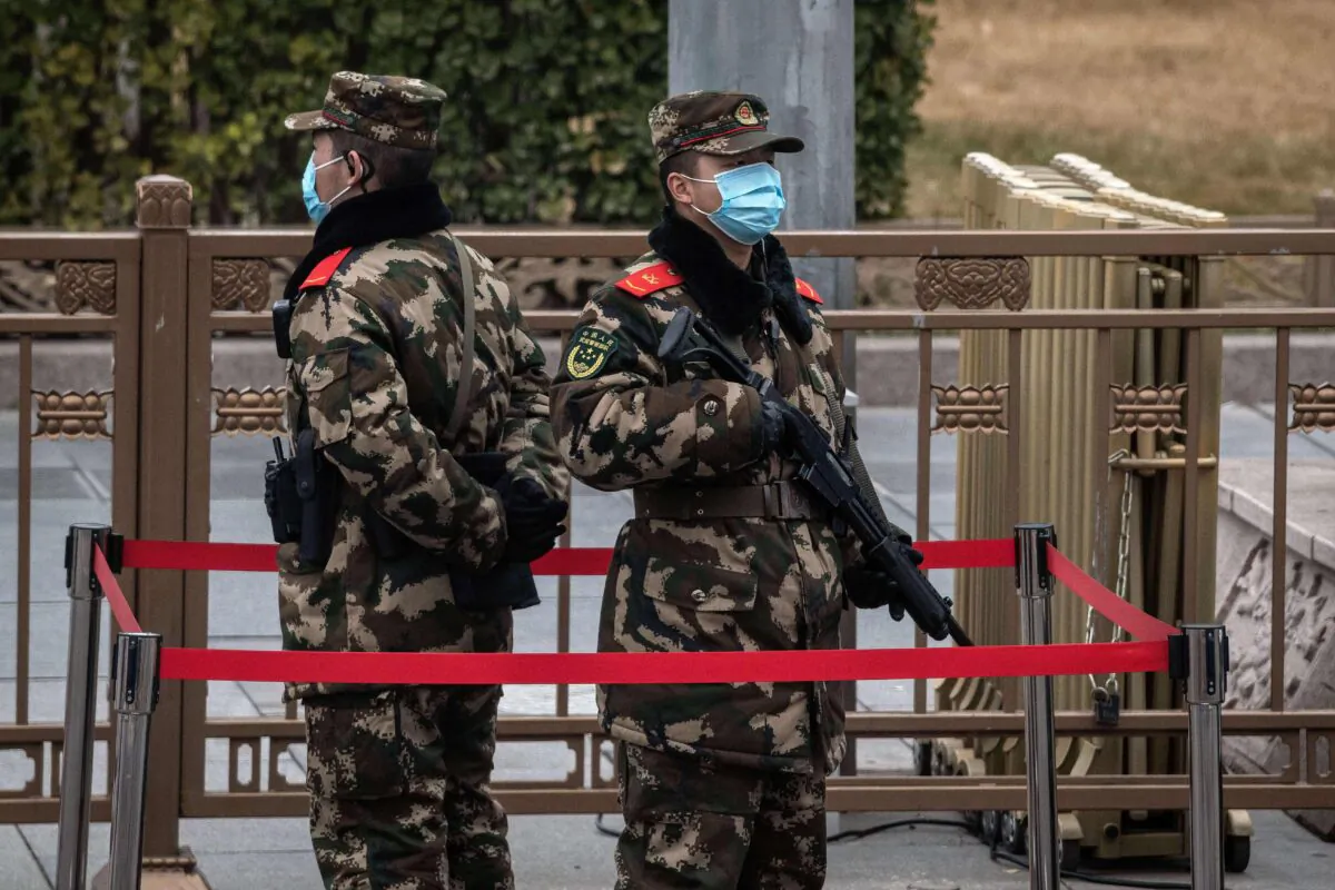 Chinese soldiers stand guard on a street intersection in Beijing, on March 3, 2021. (Nicolas Asfouri/AFP via Getty Images)