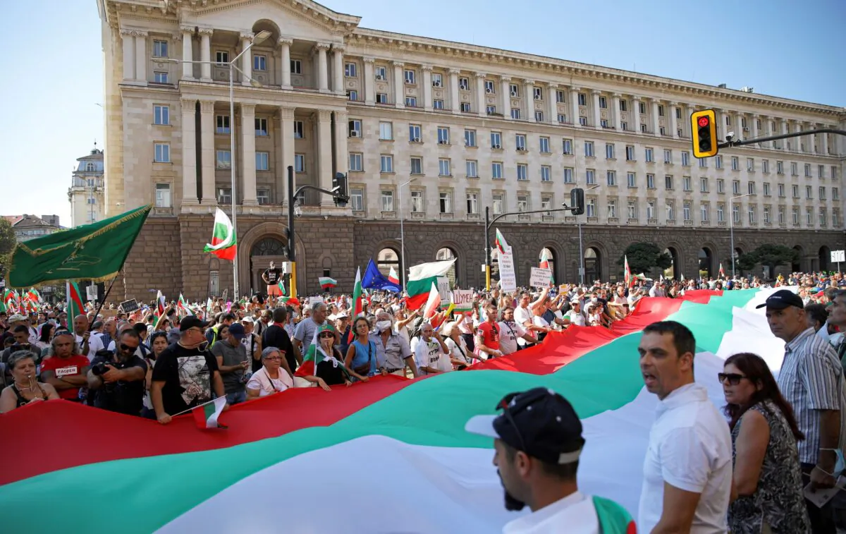 Protesters hold a large Bulgarian flag as they attend an anti-government demonstration in Sofia, Bulgaria, on Sept.10, 2020. (Stoyan Nenov/Reuters)