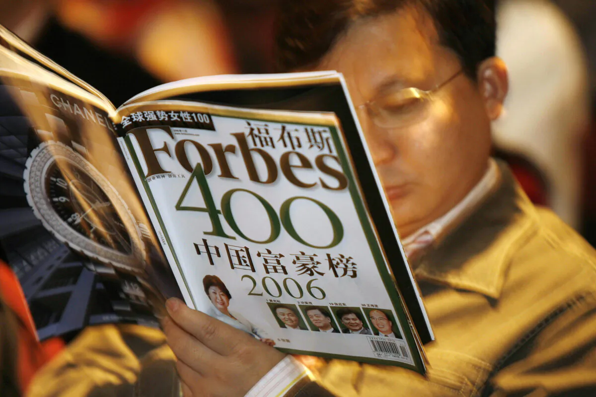 A journalist reads the latest copy of Forbes magazine at a press conference to announce the magazine's list of China's 400 wealthiest people in Beijing on Nov. 2, 2006. (Peter Parks/AFP via Getty Images)