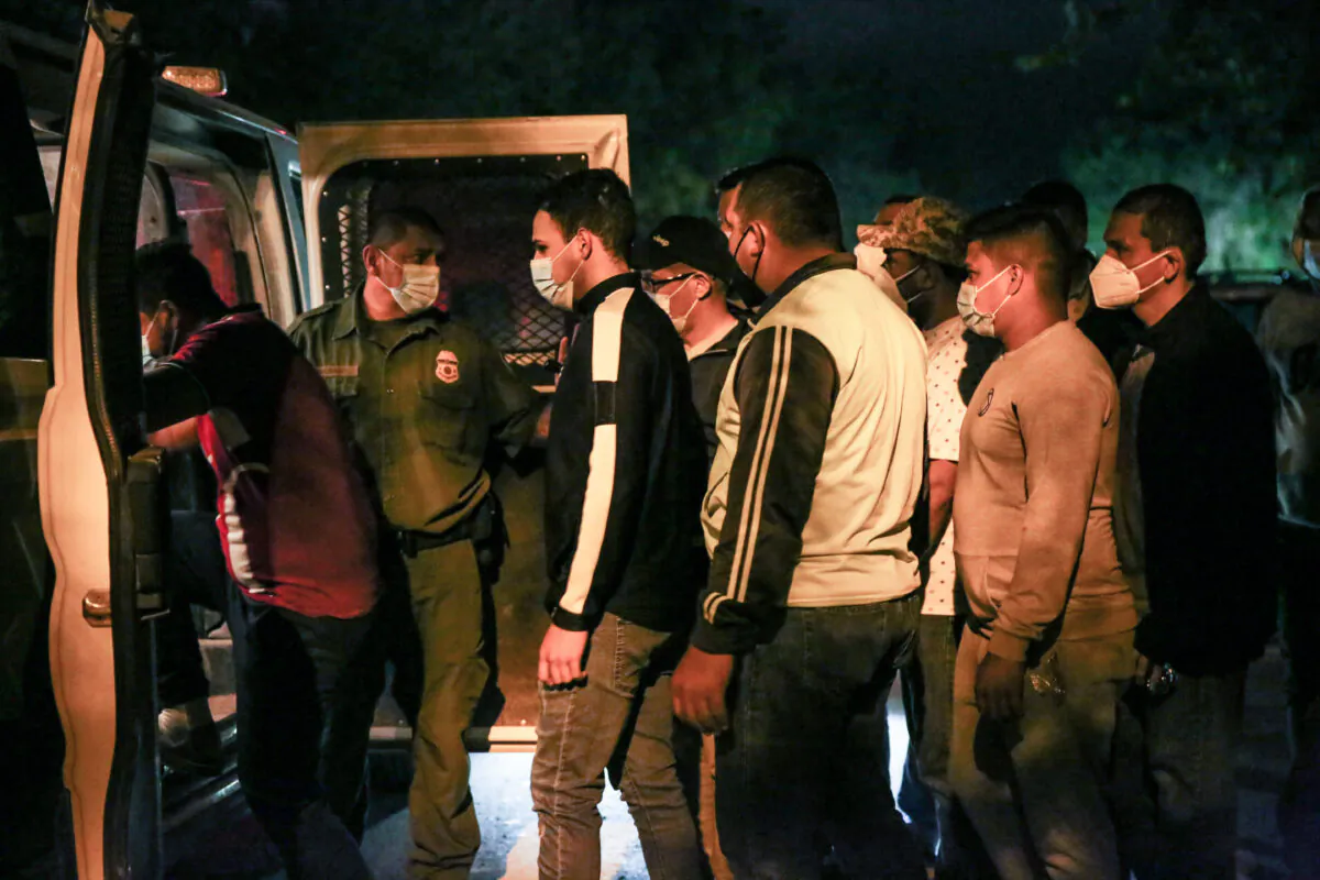 Border Patrol agents detain illegal immigrants after they cross the Rio Grande from Mexico into Del Rio, Texas, on May 23, 2021. (Charlotte Cuthbertson/The Epoch Times)