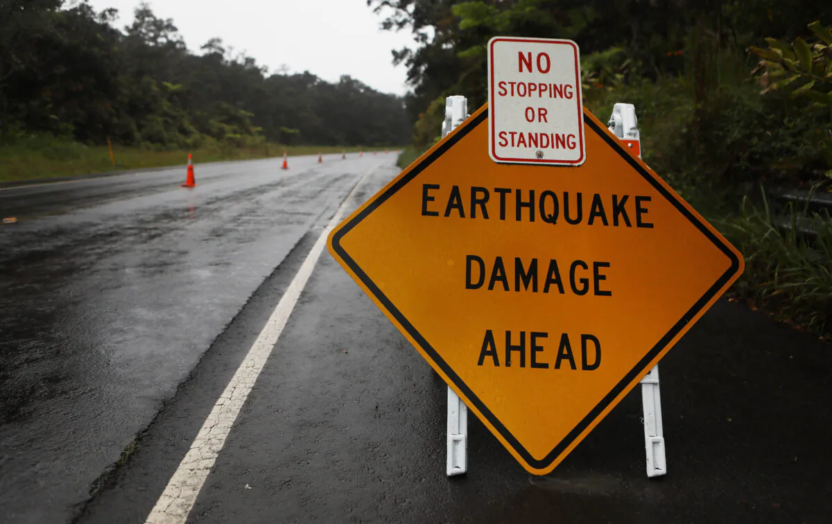 A sign is posted warning of earthquake damage to the road from seismic activity at the Kilauea volcano on Hawaii's Big Island on May 17, 2018 in Hawaii Volcanoes National Park, Hawaii. (Mario Tama/Getty Images)