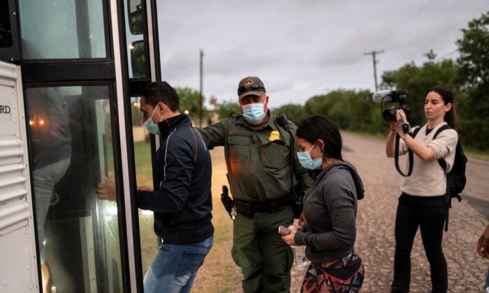 Illegal migrants board a bus after being apprehended near the border between Mexico and the United States in Del Rio, Texas, on May 16, 2021. (Sergio Flores/AFP via Getty Images) 