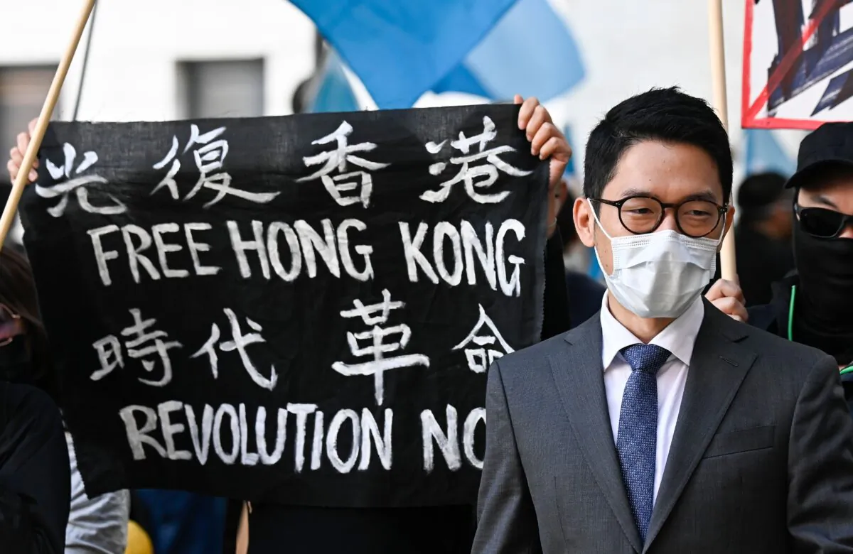Hong Kong democracy activist Nathan Law stands next to a banner reading "Free Hong Kong. Revolution now" as he attends a demonstration outside the Foreign Office in Berlin, Germany, on Sept. 1, 2020. (Tobias Schwarz/AFP via Getty Images)