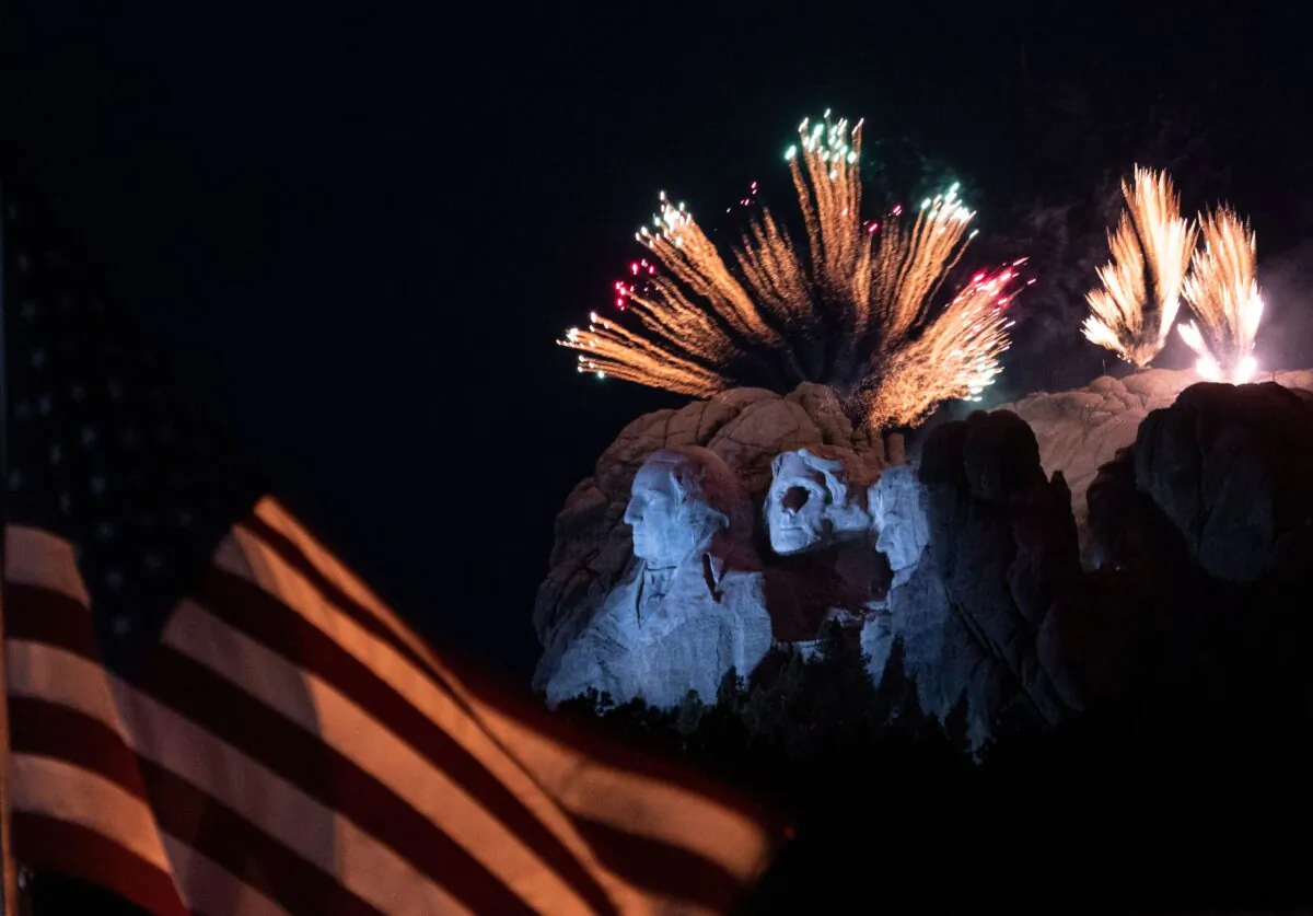 A U.S. flag flies as fireworks explode above the Mount Rushmore National Monument during an Independence Day event in Keystone, S.D., on July 3, 2020. (Andrew Caballero-Reynolds/AFP via Getty Images)