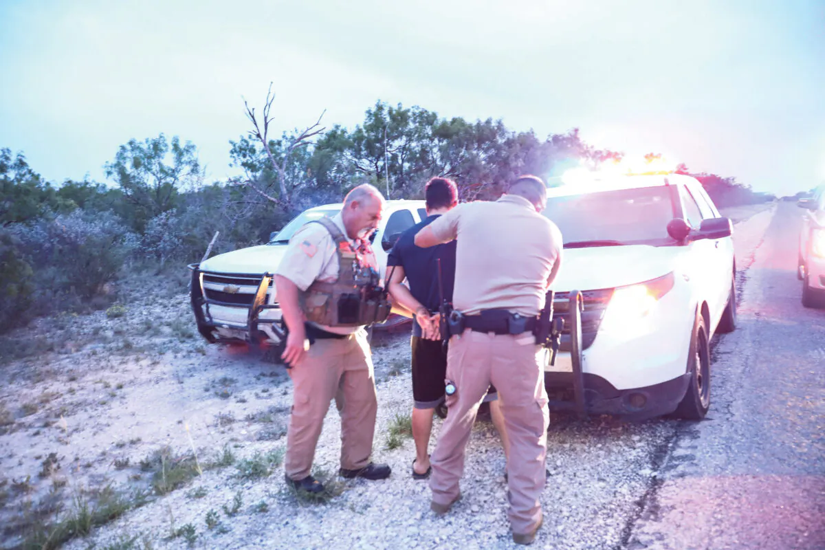 Kinney County Constable Steve Gallegos and Kinney County Sheriff’s deputies arrest a smuggler and seven illegal aliens from Guatemala near Brackettville, Texas, on May 25, 2021. (Charlotte Cuthbertson/The Epoch Times)