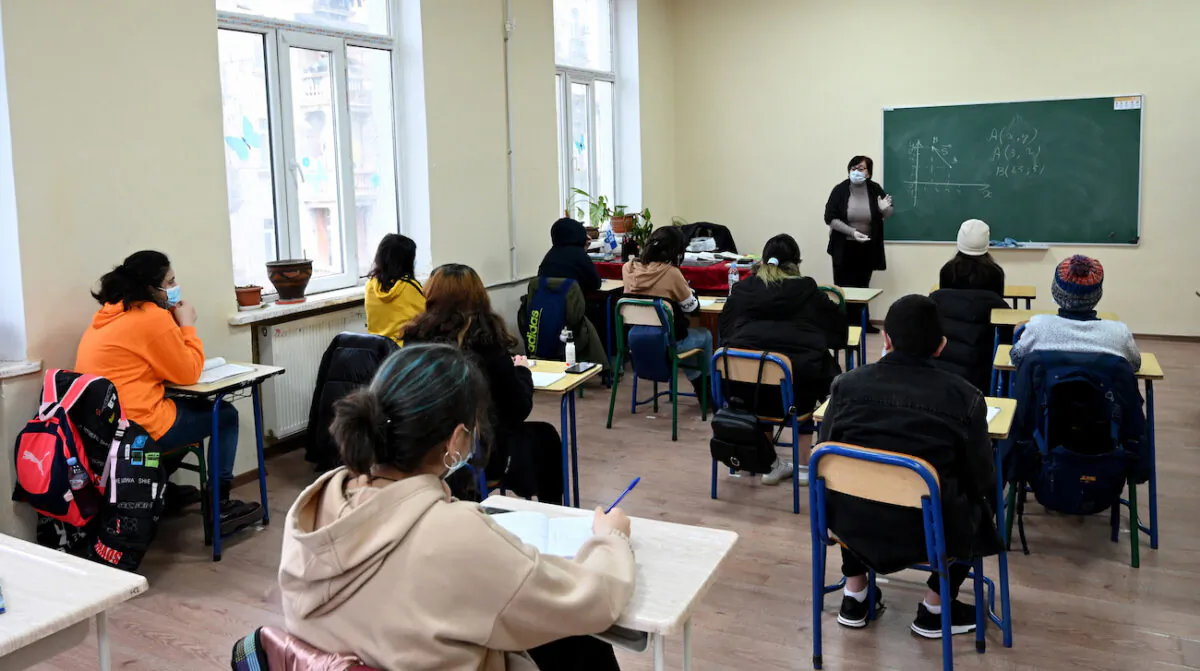 Schoolchildren wearing face masks listen to a teacher at a school in Tbilisi, Georgia on Feb. 15, 2021. (Photo by Vano Shlamov / AFP) (Photo by VANO SHLAMOV/AFP via Getty Images)