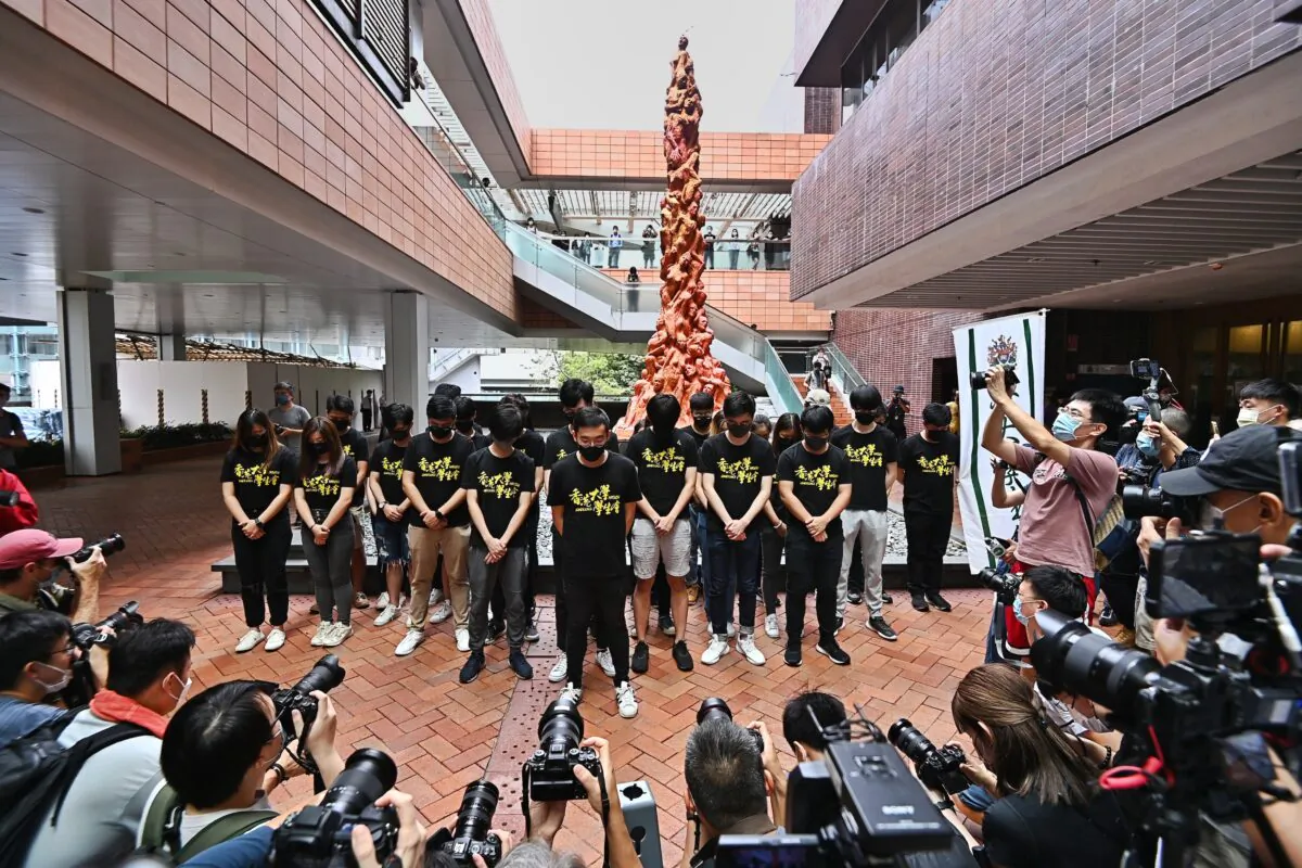 Students of the Hong Kong University Students' Union hold a moment of silence before the Pillar of Shame in Hong Kong on June 4, 2021. (Sung Pi-lung/The Epoch Times)