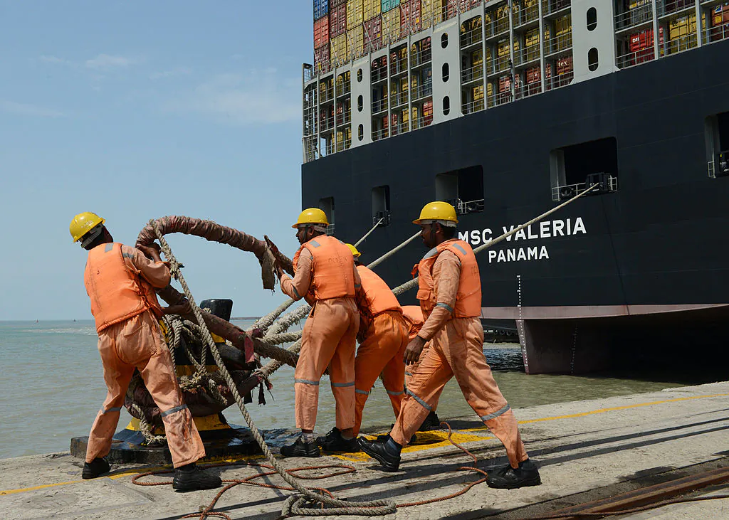 Indian dock workers tighten ropes as the MSC Valeria, an ultra-large containership from the Mediterranean Shipping Company S. A., of Geneva, docks at Adani Ports at Mundra, some 400 km from Ahmedabad on June 4, 2013.(Sam Panthaky/AFP via Getty Images)