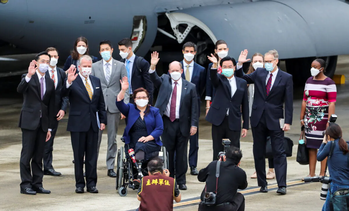 U.S. Sevs. Tammy Duckworth (D-Ill.), Dan Sullivan (R-Alaska), and Chris Coons (D-Del.) wave next to Taiwan Foreign Minister Joseph Wu, and Brent Christensen, director of the American Institute in Taiwan, after their arrival via a U.S. Air Force freighter at Taipei Songshan Airport in Taipei, Taiwan, on June 6, 2021. (Central News Agency/Pool via Reuters)