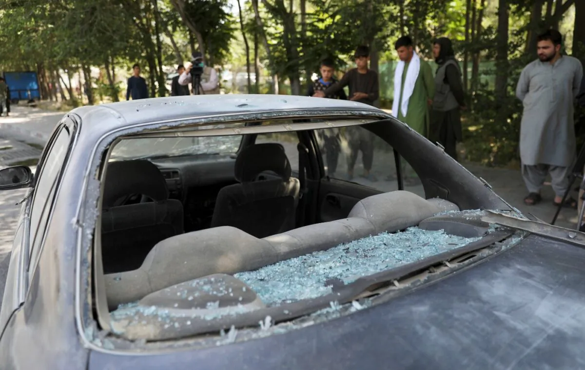 Afghan men look at a damage car after a roadside bomb explosion in Kabul, Afghanistan, on June 6, 2021. (Rahmat Gul/AP Photo)

