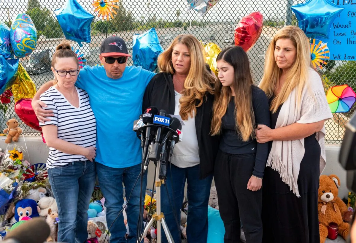 Family members of six-year-old Aiden Leos stand at a makeshift memorial on the Walnut Avenue overpass at the 55 Freeway in Orange, to announce that the reward for information leading to the suspects in the road-rage shooting death of Leos, Calif., on May 25, 2021. (Leonard Ortiz/File/The Orange County Register via AP)