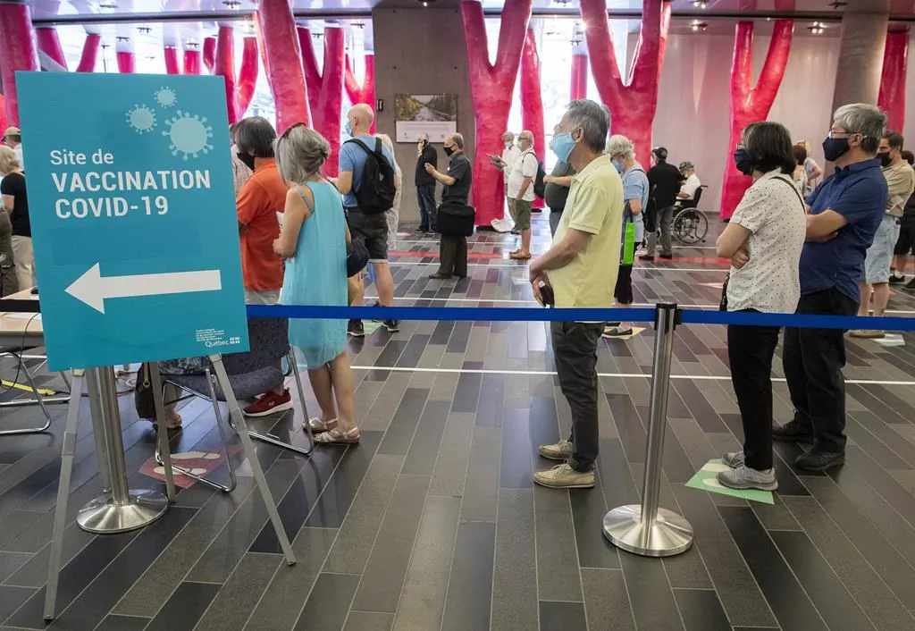 People wait in line at the Palais des congres vaccination site in Montreal on June 6, 2021. (The Canadian Press/Graham Hughes)