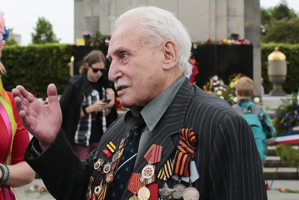 Soviet war veteran David Dushman, 92, center, speaks to people holding Ukrainian flags as he attends a wreath laying ceremony at the Russian War Memorial in the Tiergarten district of Berlin, Germany, on May 8, 2015. (Markus Schreiber/AP Photo)
