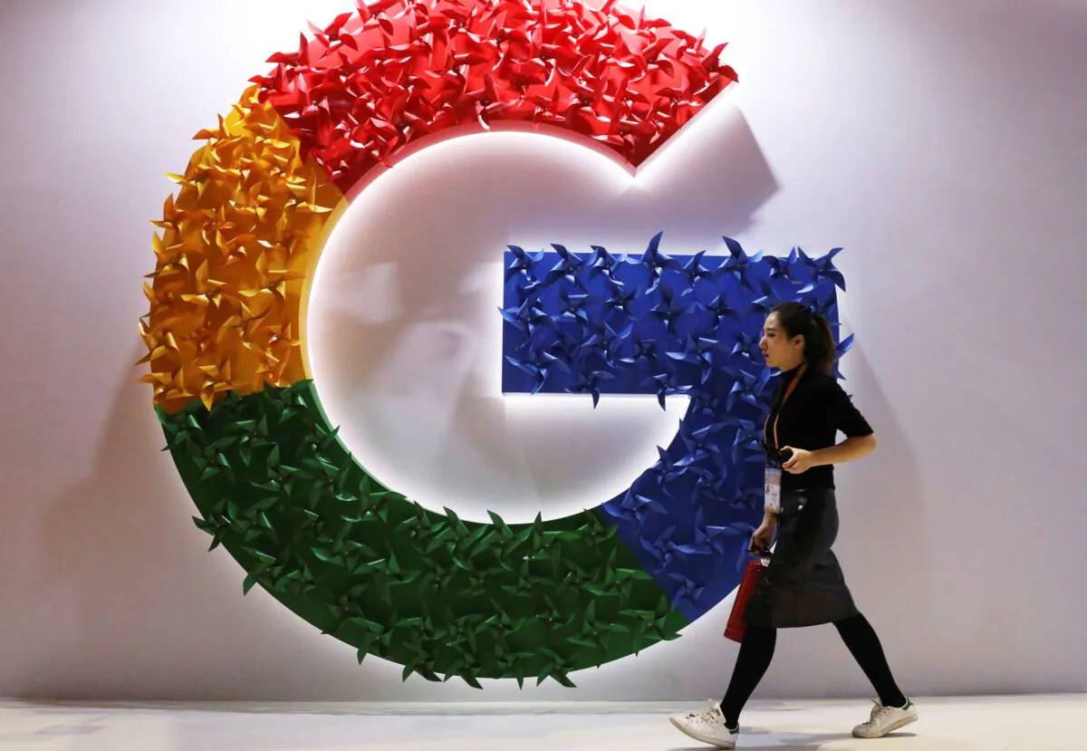 A woman walks past the logo for Google at the China International Import Expo in Shanghai, China, on Nov. 5, 2018. (Ng Han Guan/AP Photo)
