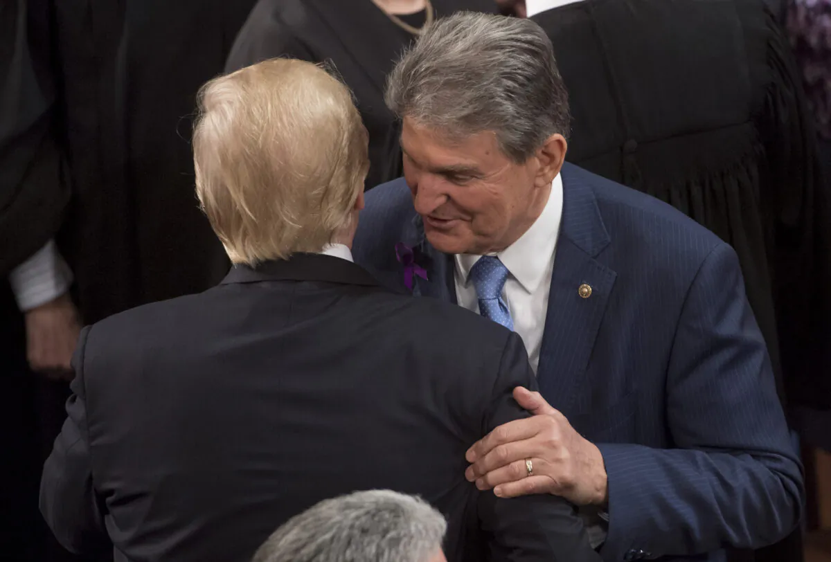 Sen. Joe Manchin (D-W.Va.) speaks with then-President Donald Trump after Trump gave a State of the Union Address before a Joint Session of Congress at the US Capitol in Washington on Jan. 30, 2018. (Saul Loeb/AFP via Getty Images)