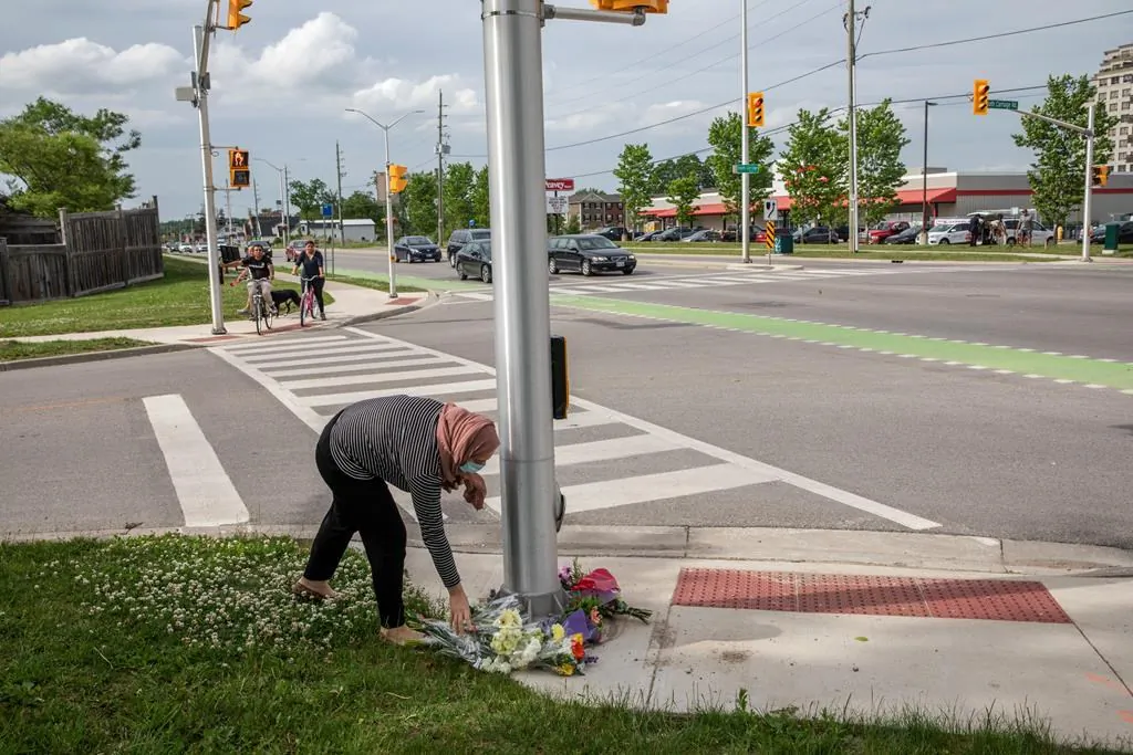 People show up to the location where a family of five was hit by a driver, in London, Ont., on June 7, 2021. Four of the members of the family died and one is in critical condition. A 20 year old male has been charged with four counts of first degree murder and count of attempted murder in connection with the crime. (The Canadian Press/Brett Gundlock)