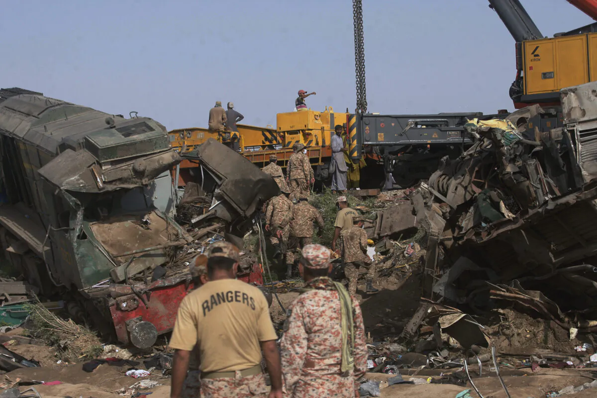 Soldiers arrive to conduct rescue operation to clear the track at the site of a train collision in the Ghotki district, southern Pakistan, on June 8, 2021. (Fareed Khan/AP Photo)