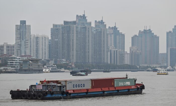 A vessel (C) transports containers along the Huangpu River in Shanghai on March 5, 2021. (Hector Retamal/AFP via Getty Images)