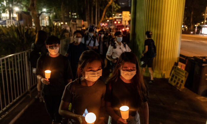 People hold candles as they walk near Victoria Park after police closed the venue where Hong Kong people traditionally gather annually to mourn the victims of China's Tiananmen Square crackdown in 1989, in the Causeway Bay district in Hong Kong on June 4, 2021. (Anthony Kwan/Getty Images)