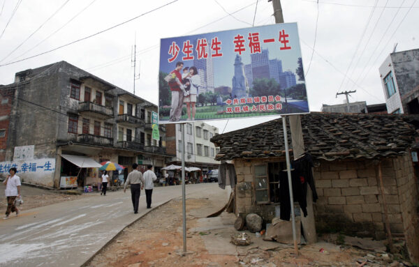 Shuangwang, CHINA: Un cartel de la política china de "un solo hijo" que dice: "Tenga menos hijos, tenga una vida mejor" saluda a los residentes en la calle principal de Shuangwang, en la región de Guangxi, en el sur de China, el 25 de mayo de 2007. Residentes de esta zona afectada por los disturbios del sur de China exigió el 25 de mayo de 2007 que las autoridades repararan una brutal campaña de tres meses para hacer cumplir las normas de planificación familiar mientras la tensión seguía siendo alta, casi una semana después de que miles de personas se enfrentaron con la policía por una campaña oficial que, según los residentes, incluía abortos forzados y destrucción de propiedades. y detenciones dirigidas a los infractores de la llamada "política del hijo único". (GOH CHAI HIN/AFP vía Getty Images)