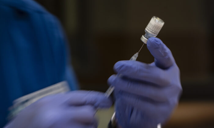 A nursing student prepares doses of the Pfizer COVID-19 vaccine for use in a vaccination clinic hosted by Odessa College in Odessa, Texas, on June 3, 2021. (Eli Hartman/Odessa American via AP)