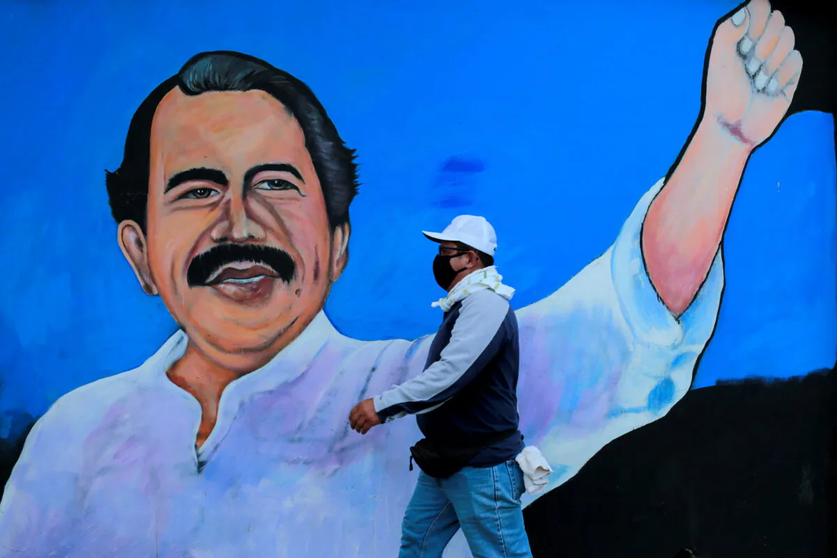A man wearing a face mask walks by a mural depicting Nicaraguan President Daniel Ortega, in Managua, Nicaragua on March 30, 2020. (Oswaldo Rivas/Reuters)