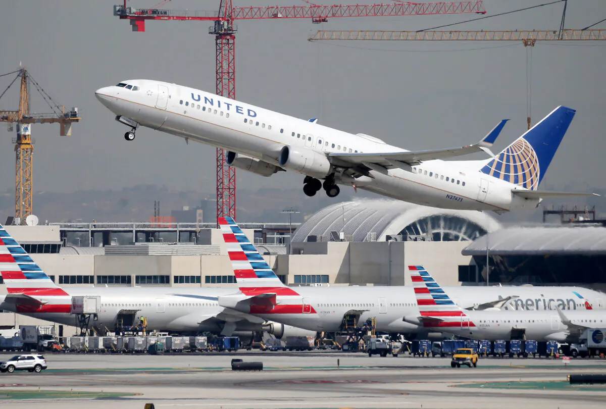 A United Airlines plane takes off above American Airlines planes on the tarmac at Los Angeles International Airport (LAX) on Oct. 1, 2020. (Mario Tama/Getty Images)