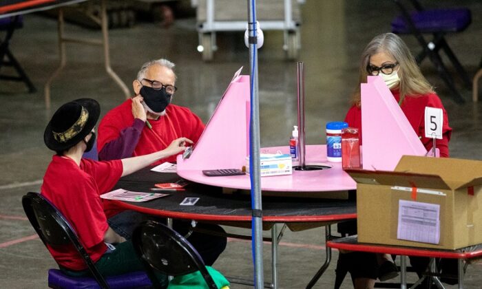 Contractors working for Cyber Ninjas, which was hired by the Arizona State Senate, examine and recount ballots from the 2020 general election at Veterans Memorial Coliseum in Phoenix, Ariz., on May 1, 2021. (Courtney Pedroza/Getty Images)