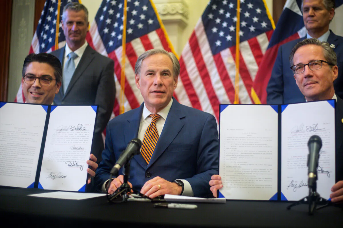 (L-R) Texas state Rep. Chris Paddie, Texas Gov. Greg Abbott, and Texas state Sen. Kelly Hancock show off Senate bills 2 and 3 during a press conference at the State Capitol in Austin, Texas, on June 8, 2021. (Montinique Monroe/Getty Images)