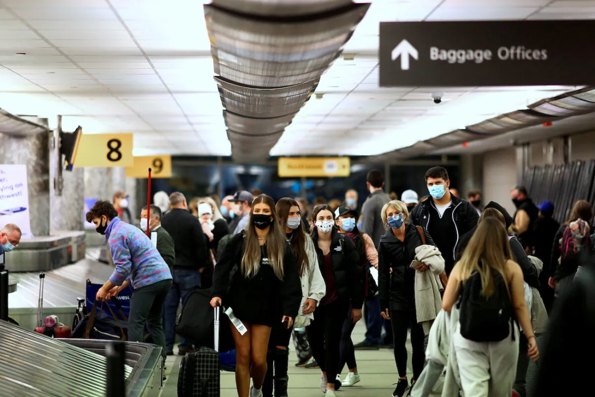 Travelers reclaim their luggage at the airport in Denver, Colorado, on Nov. 24, 2020. (Kevin Mohatt/Reuters)