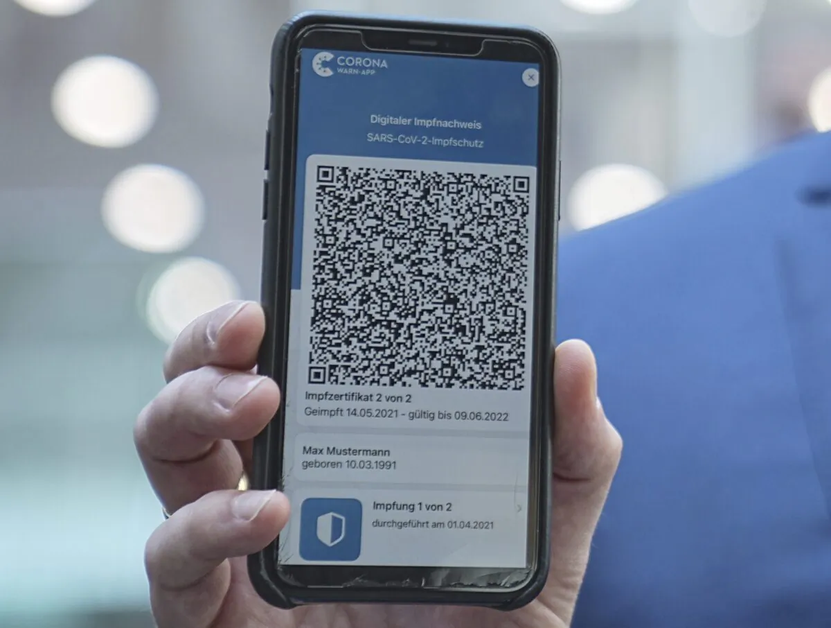 Jens Spahn (CDU), Federal Minister of Health, shows the app for the digital vaccination certificate at the regular press conference on the Corona situation in Berlin, Germany, on June 10, 2021. (Michael Kappeler/DAP via AP)