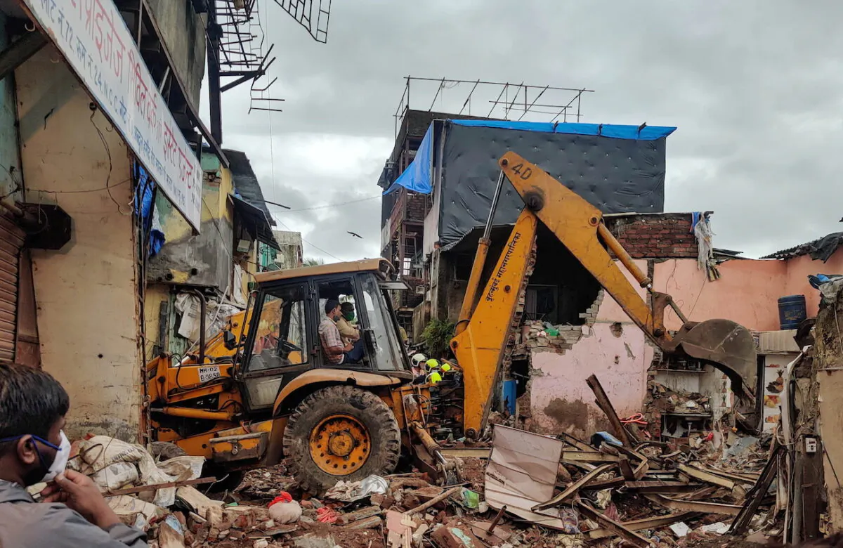 Rescue workers search for survivors in the debris after a residential building collapsed in Mumbai, India, June 10, 2021. (Hemanshi Kamani/Reuters)