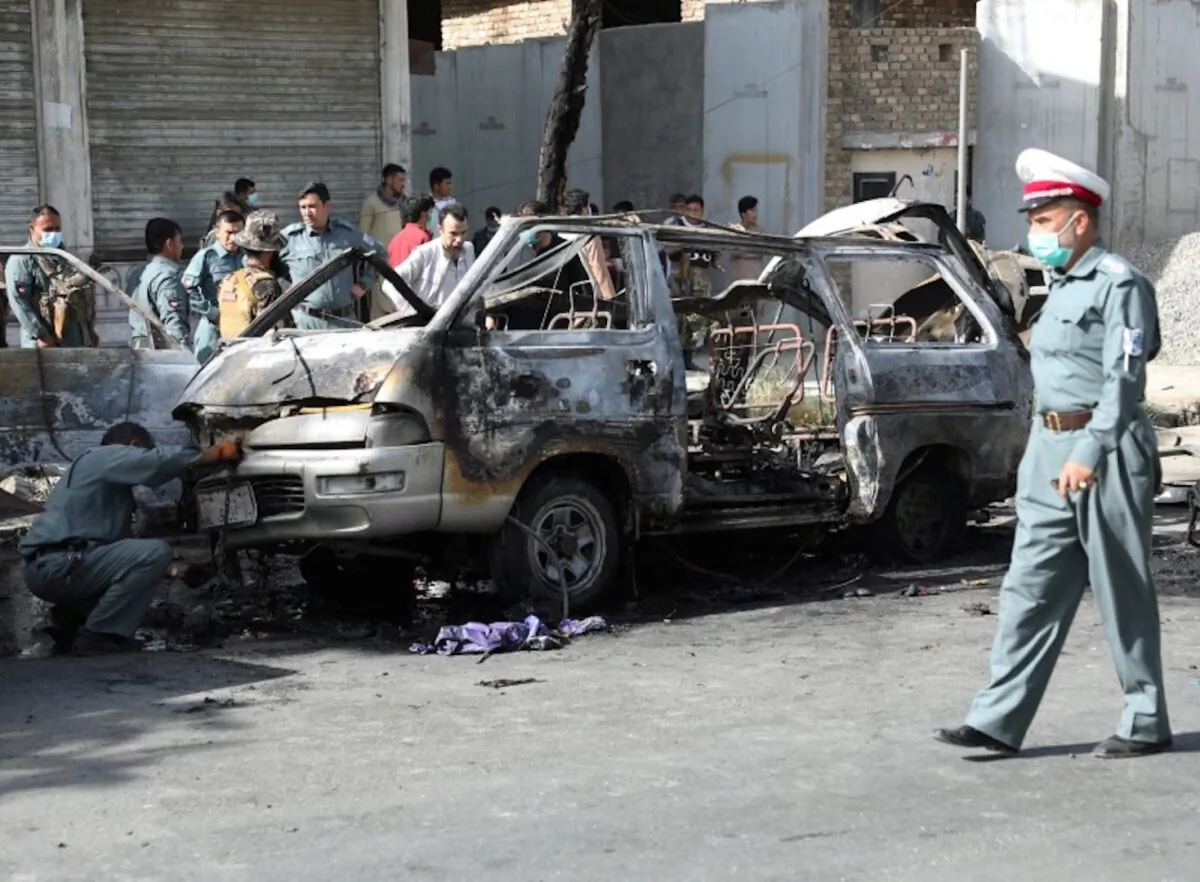 Afghan security forces inspect the wreckage of a passenger van after a blast in Kabul, Afghanistan on June 12, 2021. (Stringer via Reuters)