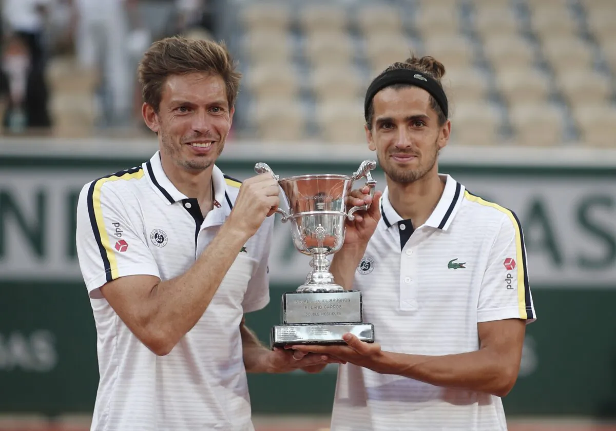 France's Pierre-Hugues Herbert and Nicolas Mahut celebrate with the trophy after winning their men's doubles final match against Kazakhstan's Alexander Bublik and Andrey Golubev, of the French Open tennis tournament, at Roland Garros stadium, Paris, France, on June 12, 2021. (Benoit Tessier/Reuters)