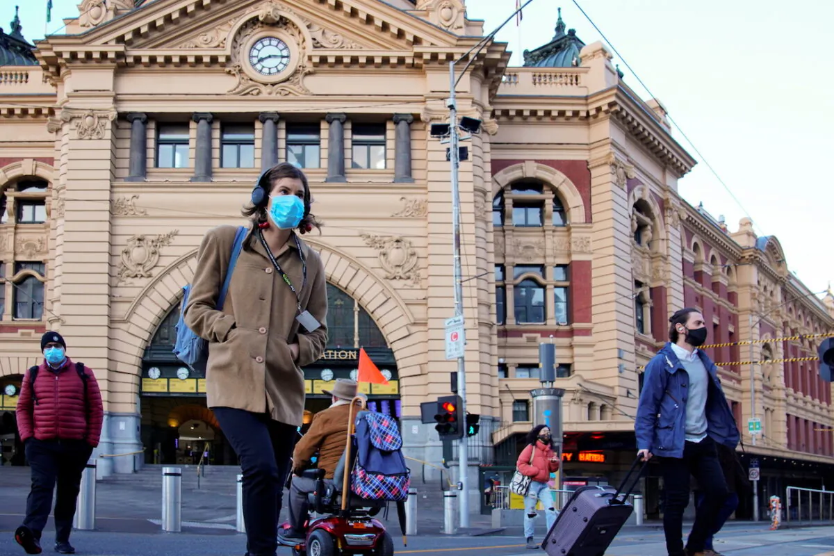 Pedestrians cross the road at Flinders Street Station in Melbourne, Australia, June 11, 2021. (Sandra Sanders/Reuters)