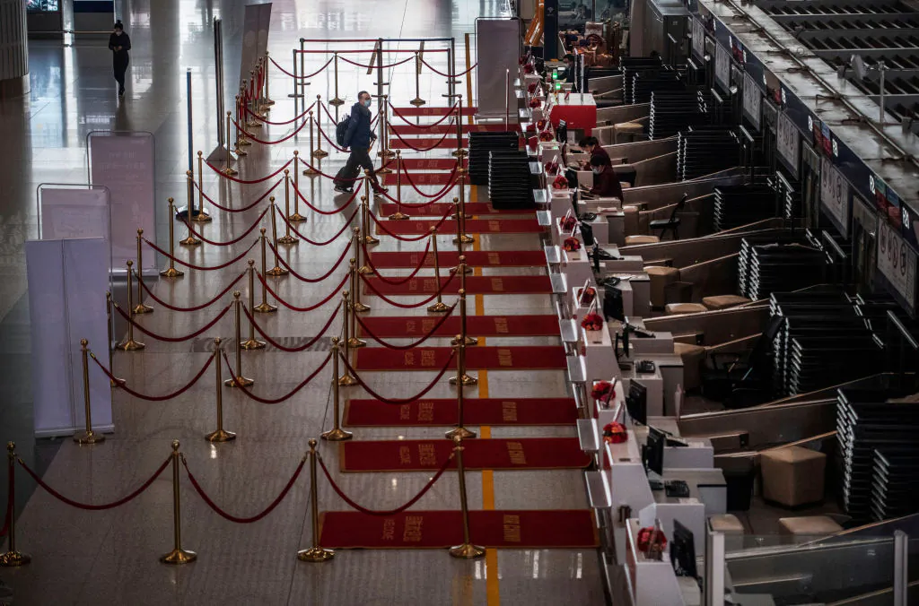 A Chinese traveler checks in for a flight in the nearly empty departures area at Beijing Capital International Airport on March 24, 2020. (Kevin Frayer/Getty Images)