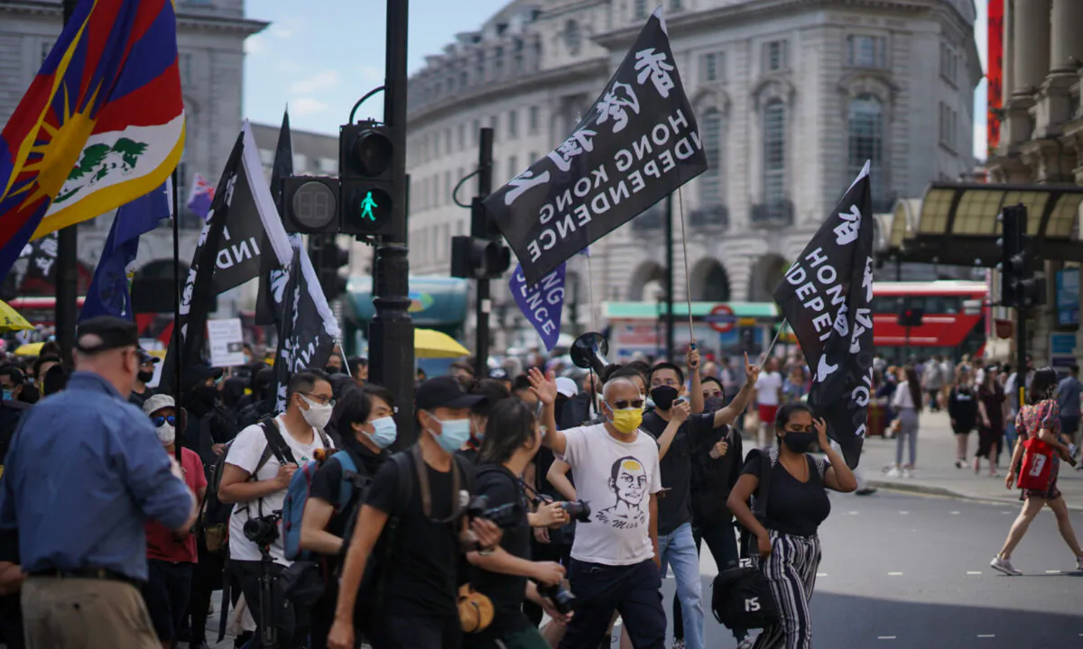 Supporters of Hong Kong's pro-democracy movement marching after a rally commemorating the two-year anniversary of Hong Kong's pro-democracy movement in London on June 12, 2021. (Yanning Qi/The Epoch Times)