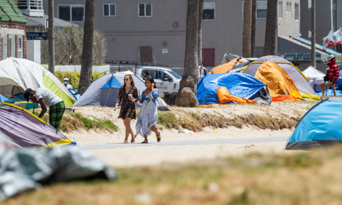 Women walk past homeless encampments in Venice Beach, Calif., on June 8, 2021. (John Fredricks/The Epoch Times)