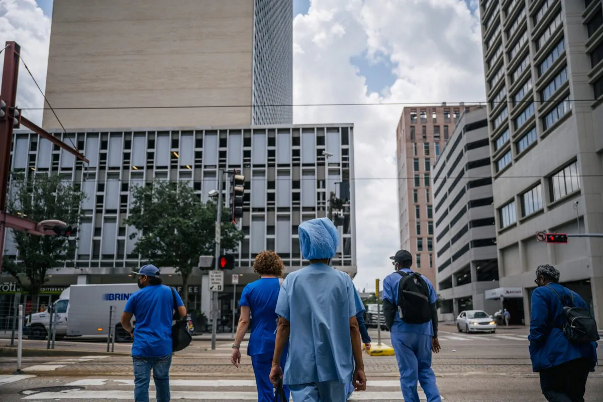 Medical workers and pedestrians cross an intersection outside the Houston Methodist hospital in Houston, Texas, on June 9, 2021. (Brandon Bell/Getty Images)
