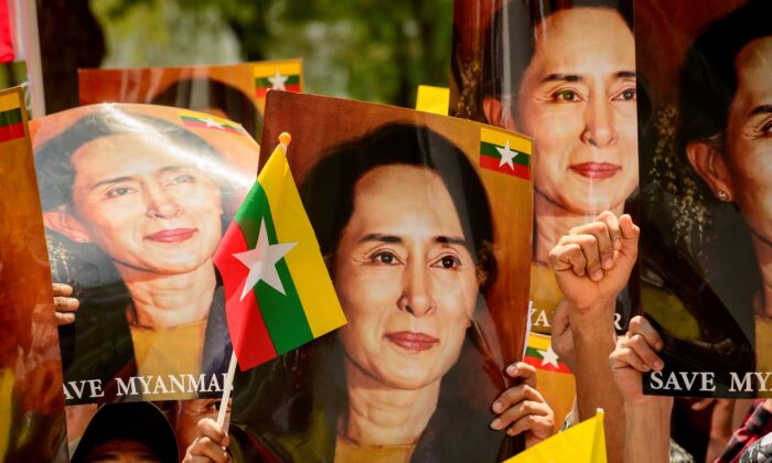 A protester holds a sign with an image of detained civilian leader Aung San Suu Kyi as they prepare to face off against security forces during a demonstration against the military coup in Yangon, Burma, on March 5, 2021. (STR/AFP via Getty Images)