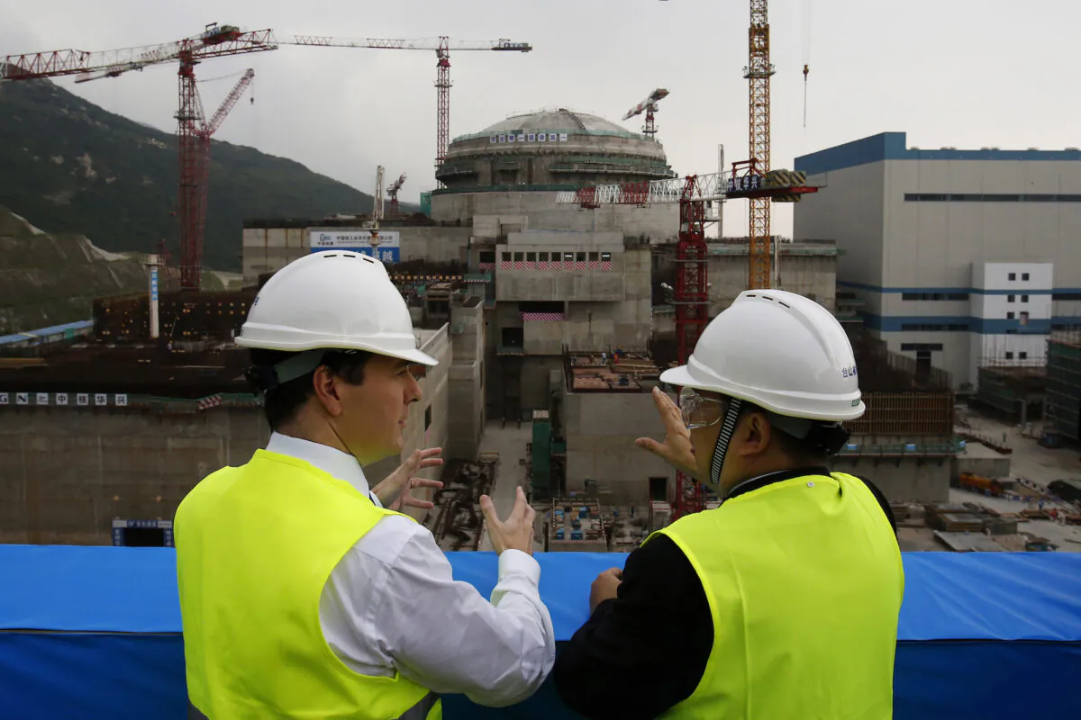 Then British Chancellor of the Exchequer George Osborne (L) chats with Taishan Nuclear Power Joint Venture Co. Ltd. General Manager Guo Liming, as they inspect a nuclear reactor under construction at the nuclear power plant in Taishan, China, on Oct. 17, 2013. (Bobby Yip, Pool, File/AP Photo)