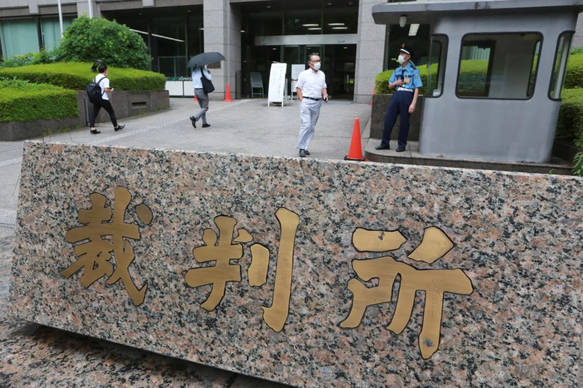 People walk in the compound of the Tokyo District Court where a trial of two Americans suspected of helping former Nissan chairman Carlos Ghosn flee Japan, opens in Tokyo, on June 14, 2021. (Koji Sasahara/AP Photo)